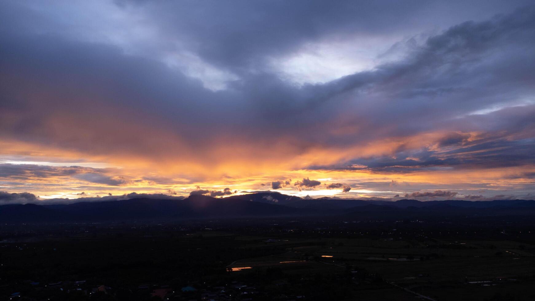 réel incroyable lever du soleil ou le coucher du soleil ciel avec doux coloré des nuages. magnifique Naturel le coucher du soleil de le Montagne intervalle en dessous de coloré bleu et Orange le coucher du soleil dans le soir. photo