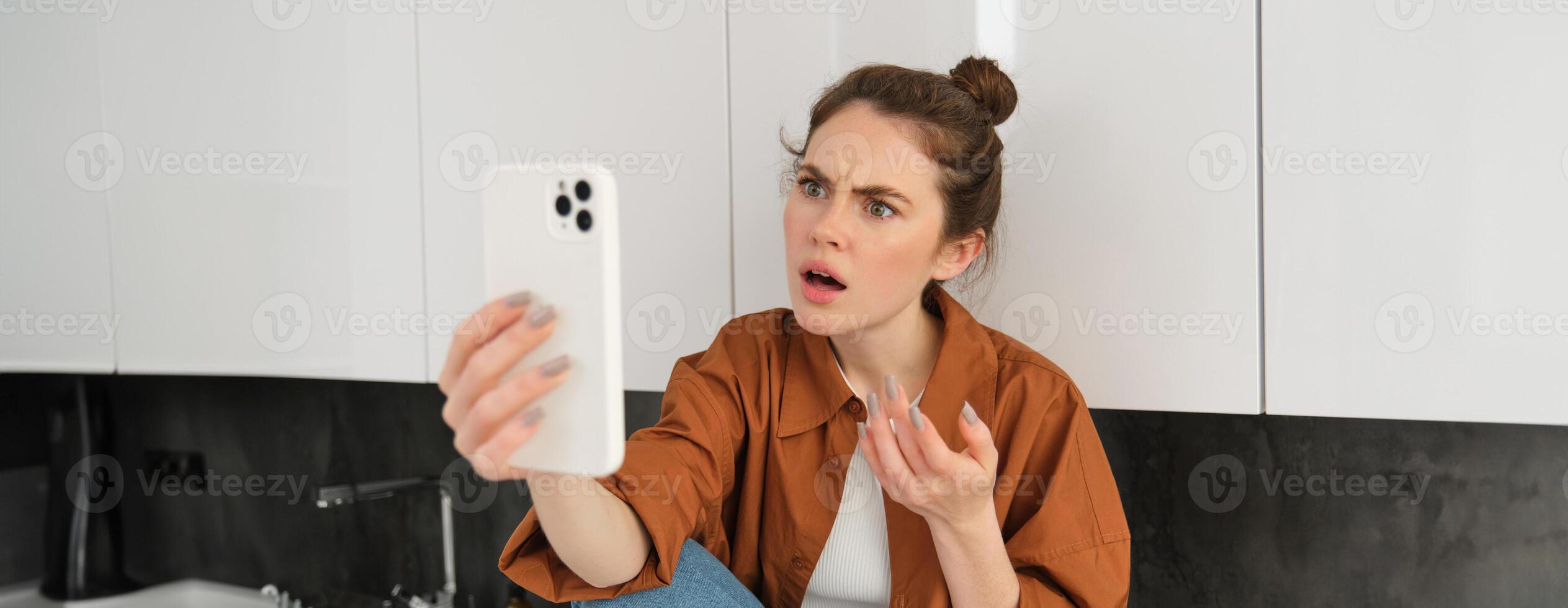 portrait de femme avec confus affronter, parlant à téléphone intelligent, vidéo chats, exprime frustration et déception photo