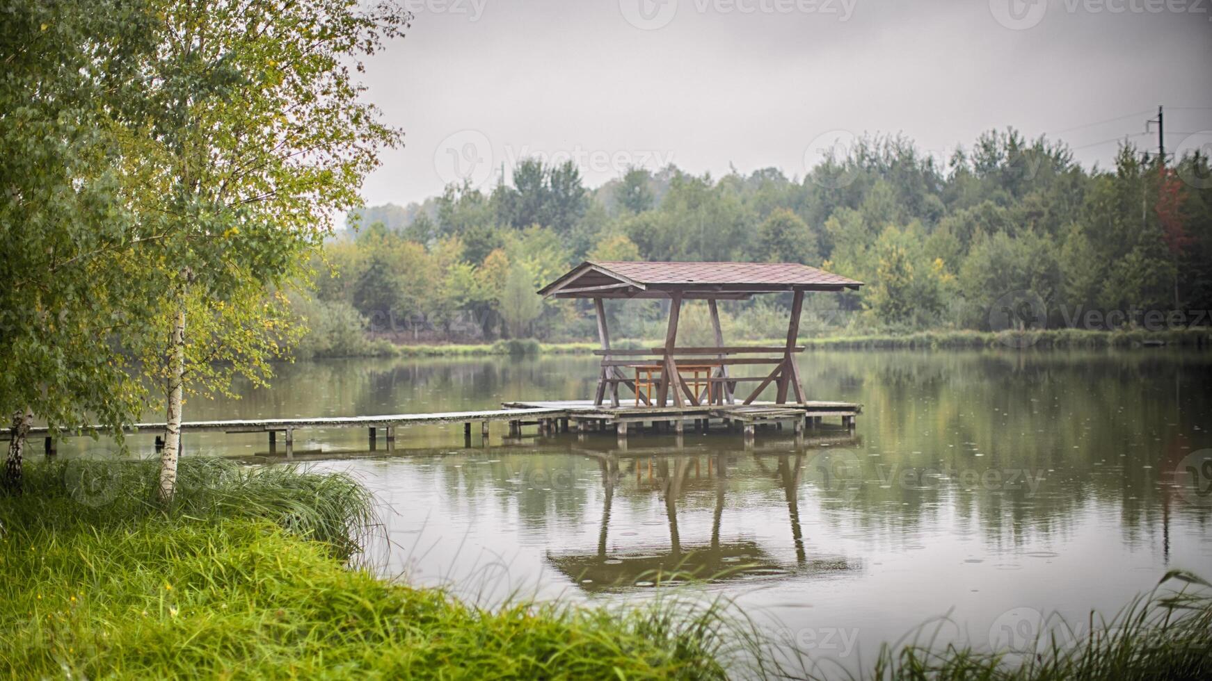 belvédère avec chaises et une table des stands sur une en bois maçonnerie dans le milieu de le Lac photo