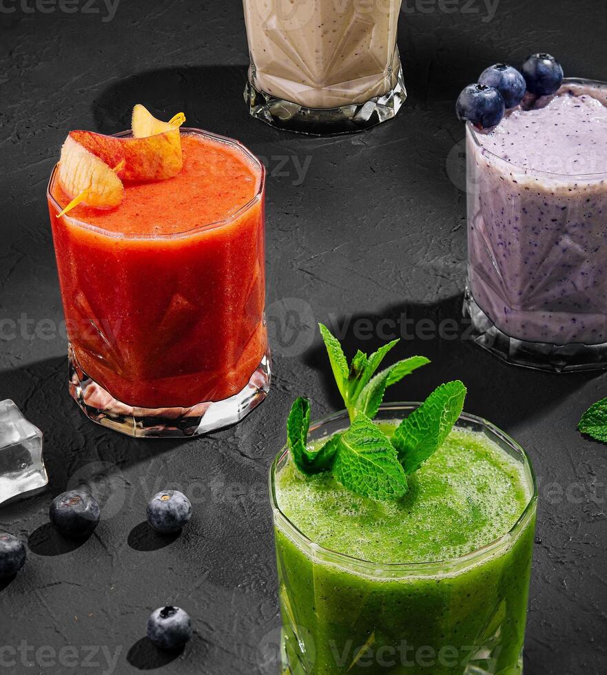 fraîchement mélangé fruit smoothies de divers couleurs et goûts dans verre photo