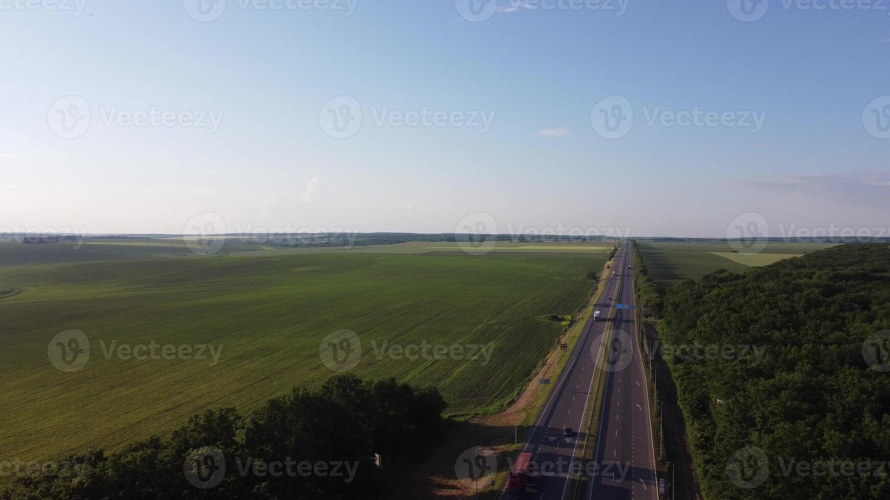 aérien vue sur Autoroute route par vert des champs sur une été ensoleillé journée. 4k métrage de paysage avec asphalte autoroute entre Prairie et rural champ. drone pousse vidéo de le campagne. photo