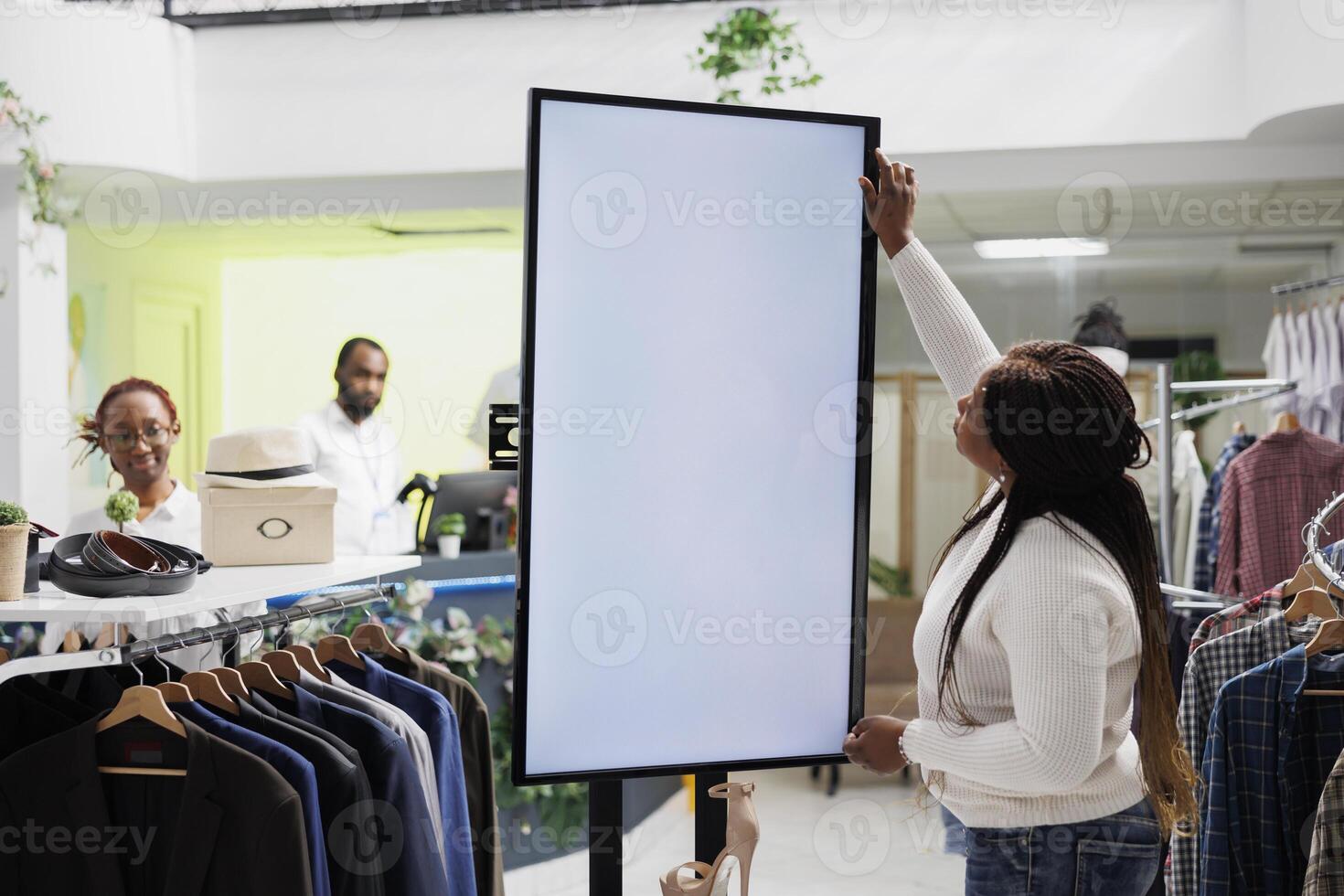 boutique client navigation chaussure sur blanc Vide numérique écran dans achats centre. africain américain femme examiner des chaussures marque Nouveau collection en utilisant interactif tableau blanc dans boutique photo