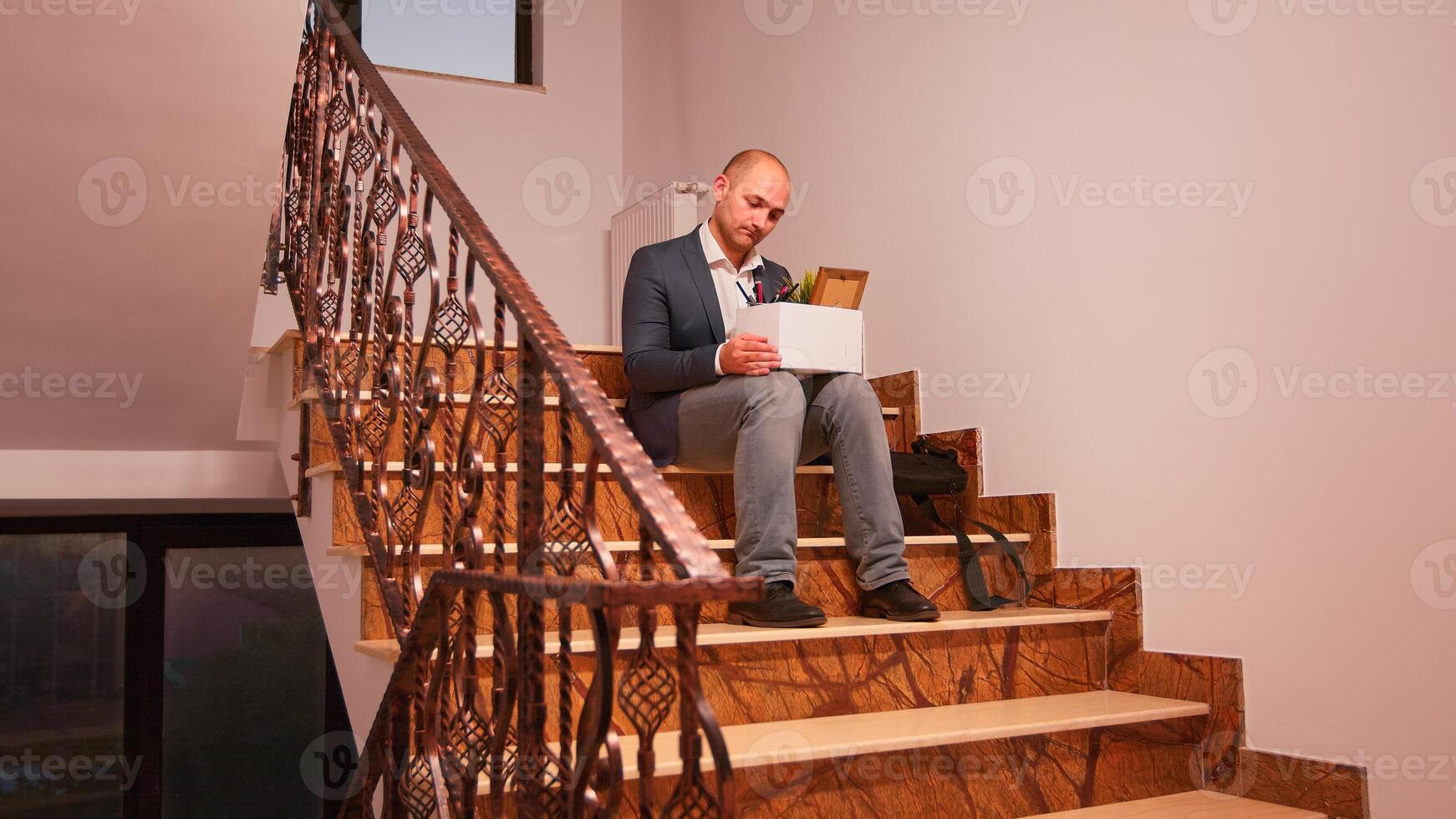 dérangé affaires entreprise employé séance sur escaliers en portant boîte de personnel truc, avoir mis à la porte de entreprise. groupe de professionnel réussi hommes d'affaires travail dans moderne financier bâtiment. photo