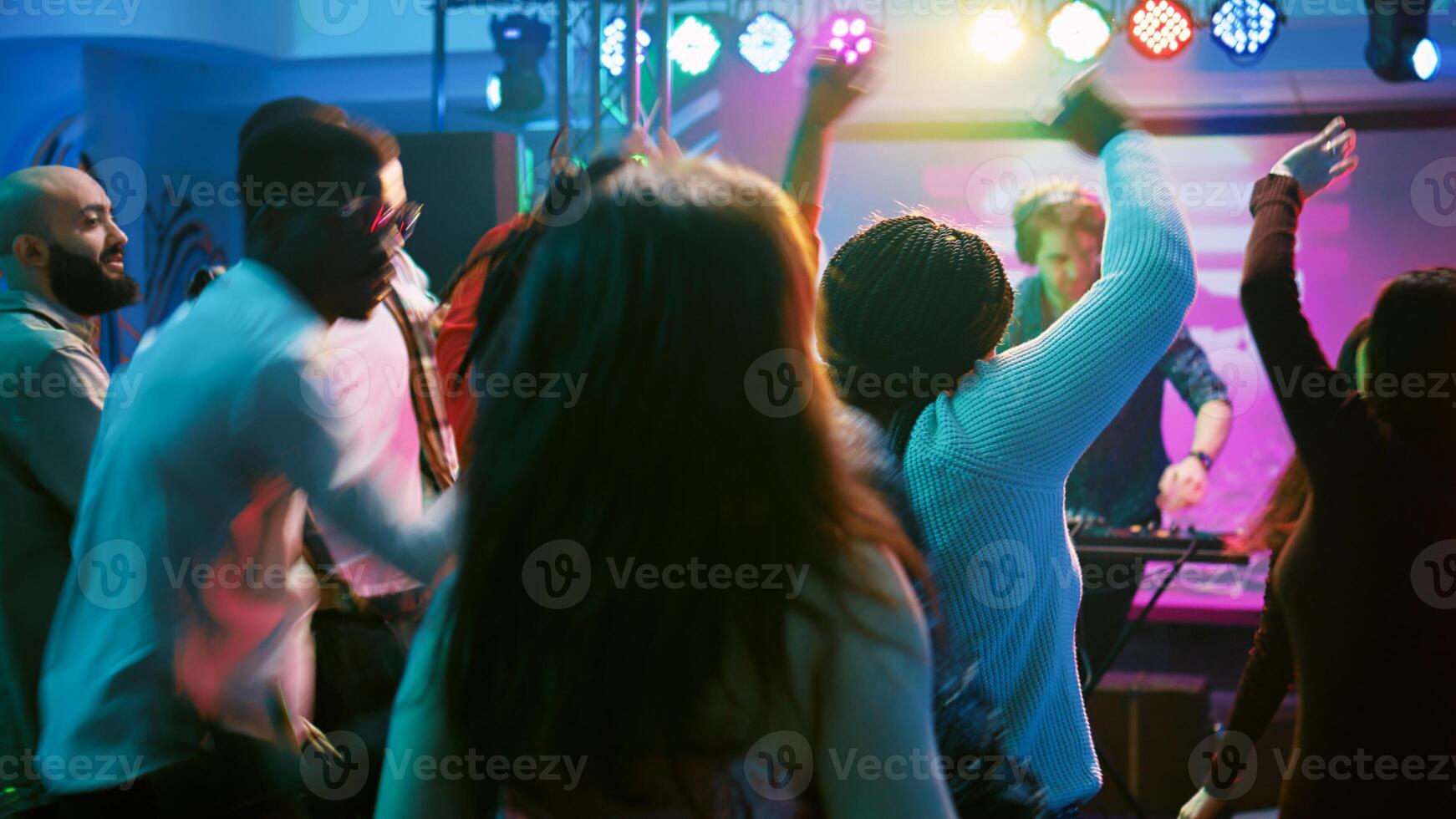 groupe de copains profiter fête à club, dansant sur moderne la musique et sauter sur Danse sol. Jeune gens sentiment content et montrant cool se déplace à discothèque, aller en boîte. ordinateur de poche tir. photo