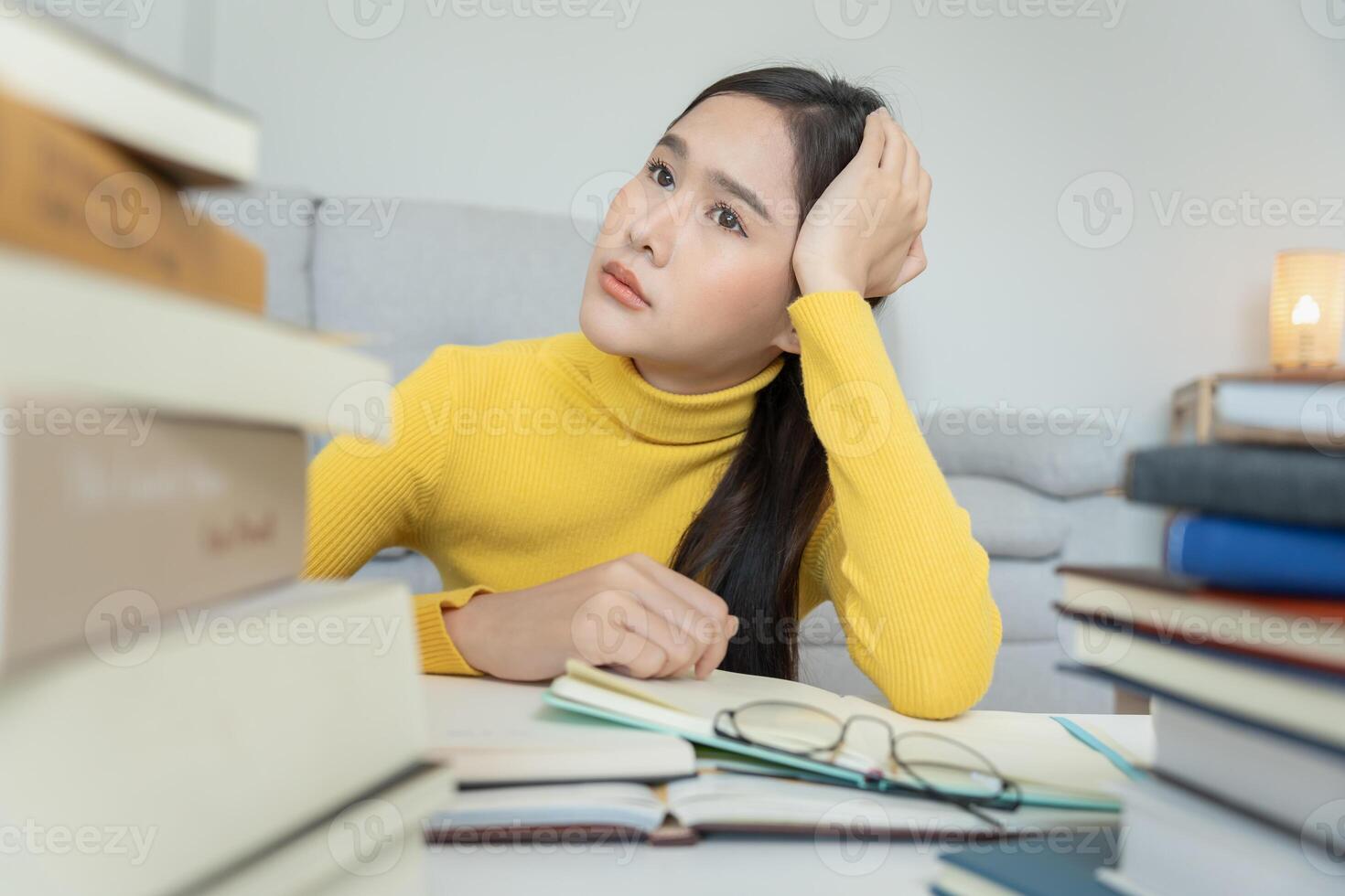 une étudiante asiatique a de l'anxiété à cause des examens, les femmes se préparent aux tests et apprennent les leçons à la bibliothèque. stress, désespoir, hâte, incompréhension lecture, découragement, attente, connaissance photo