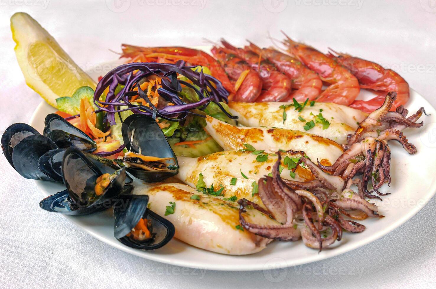 assiette avec grillé Fruit de mer. moules, seiche, crevette, citron photo