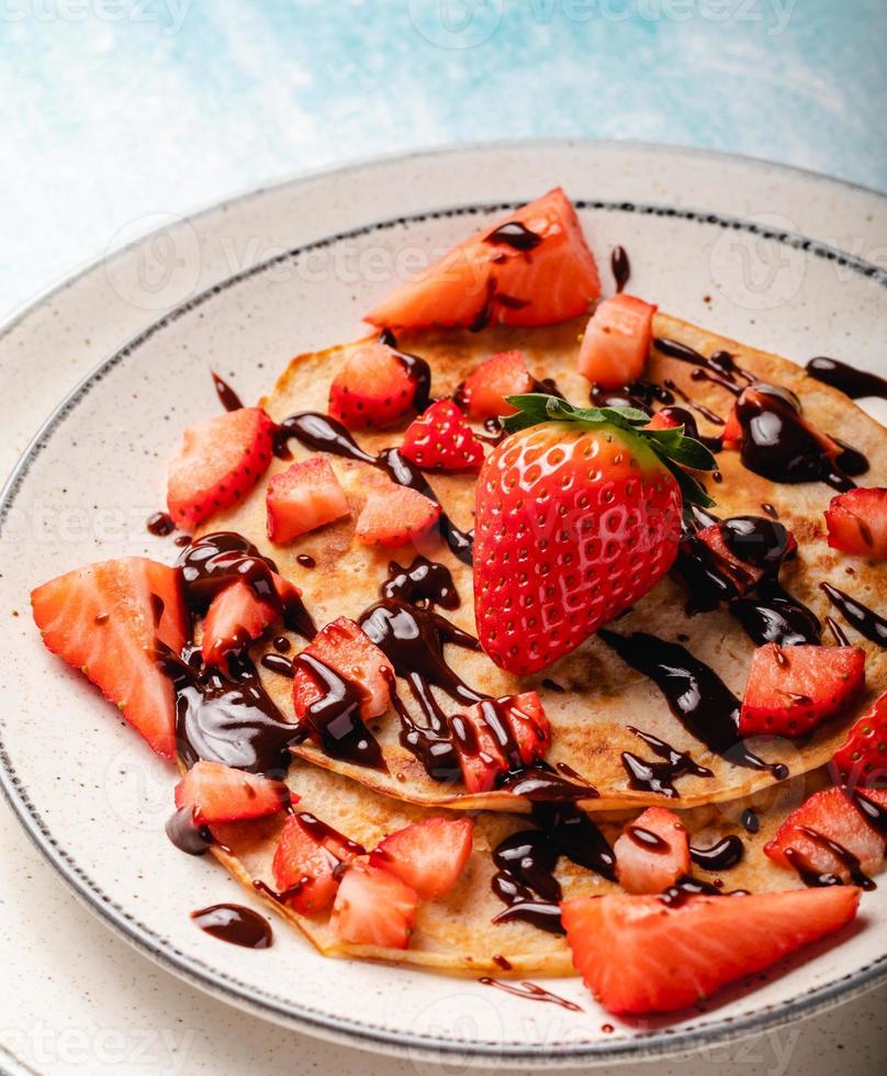 crêpes aux fraises fraîches sur un fond en bois bleu photo