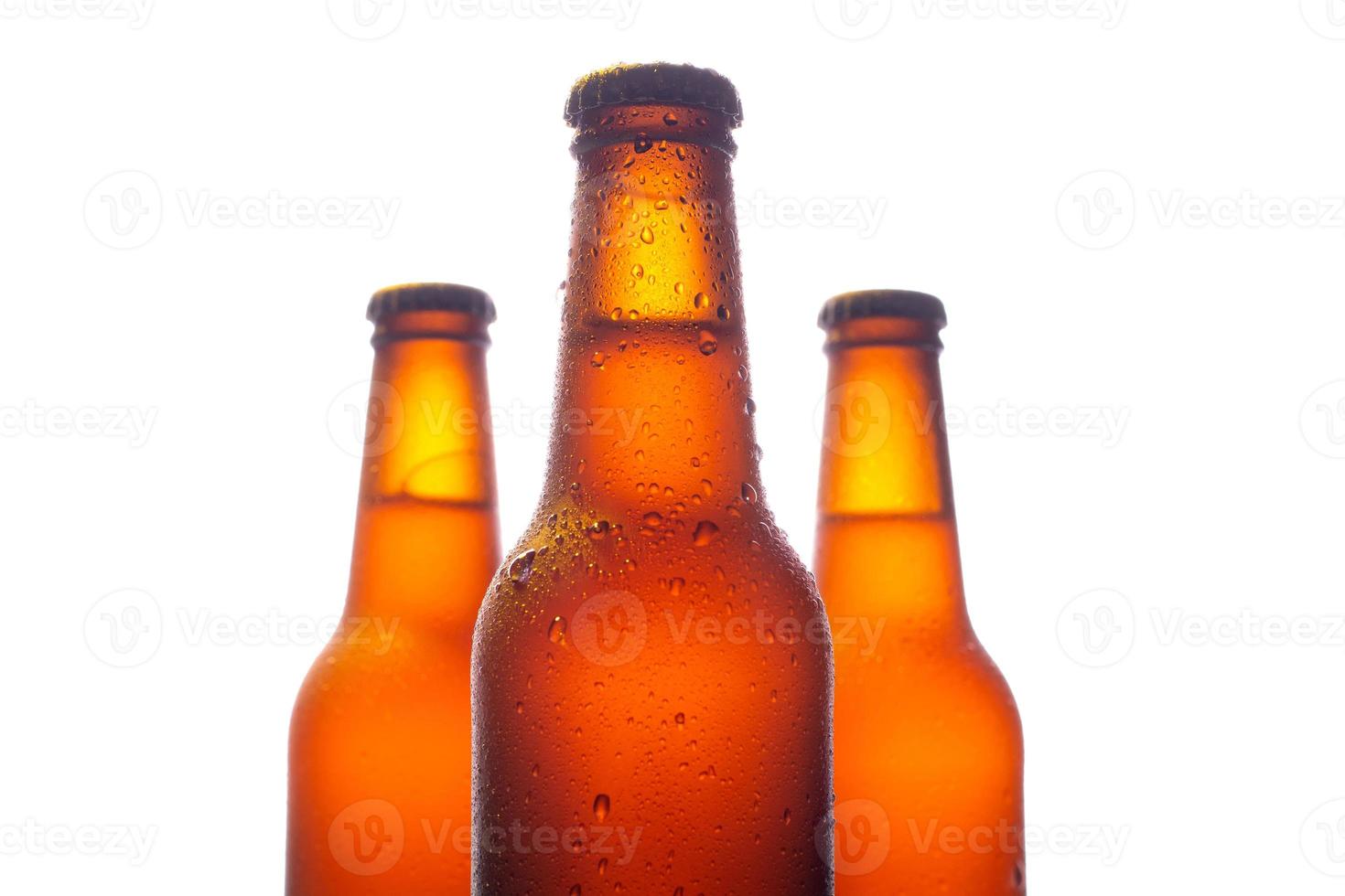 trois bouteilles de bière fraîche avec de grosses gouttes d'eau sur fond blanc photo