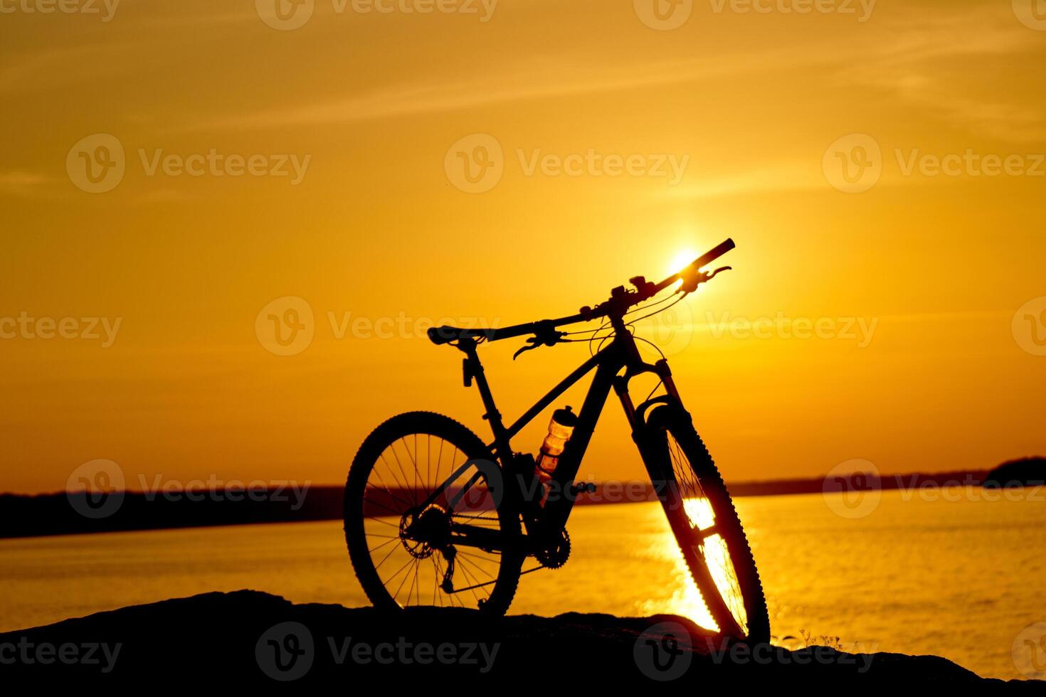 bicyclette à côté de l'eau avec le coucher du soleil. actif mode de vie concept photo