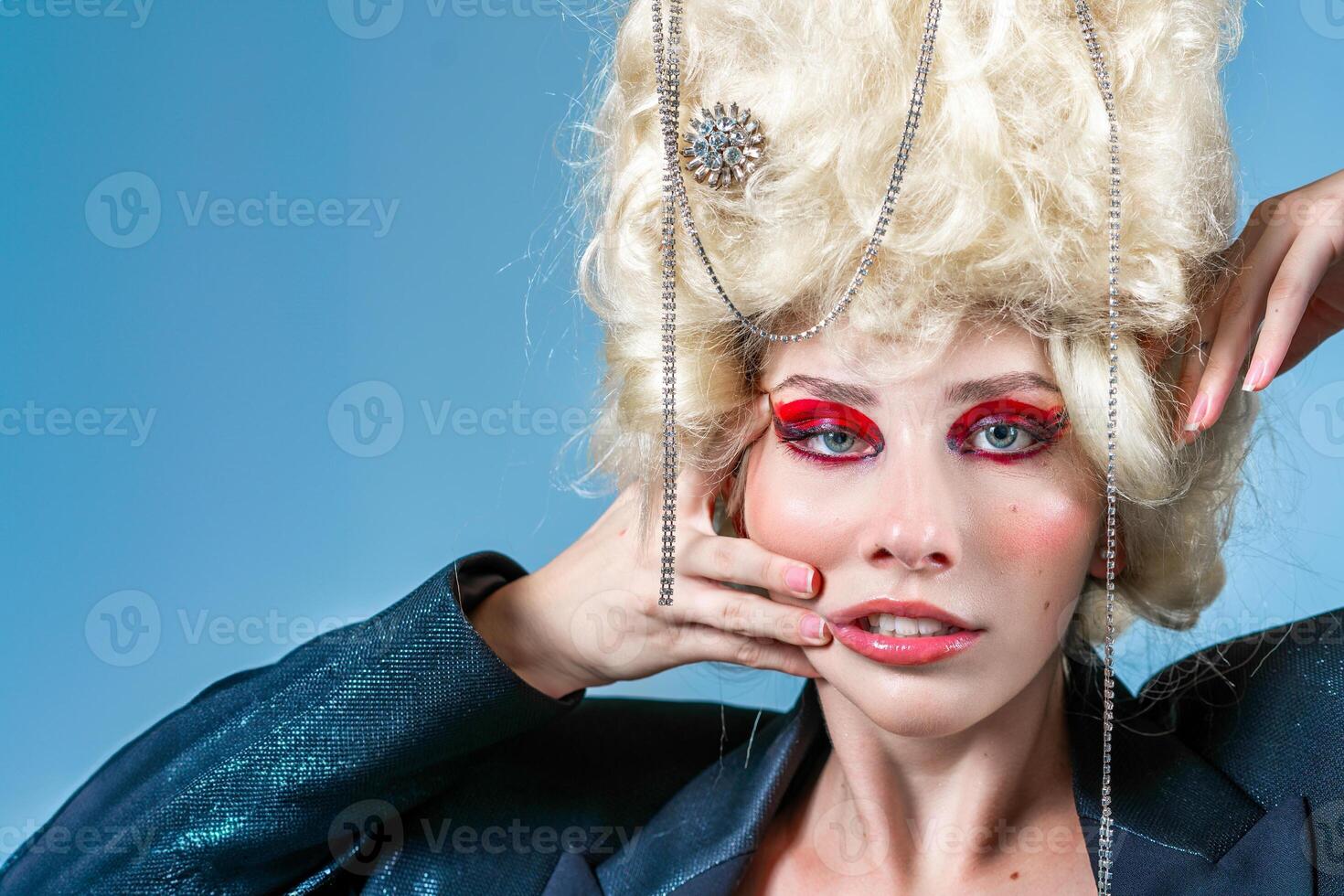 marrant femme portant perruque et maquillage dans bleu studio photo