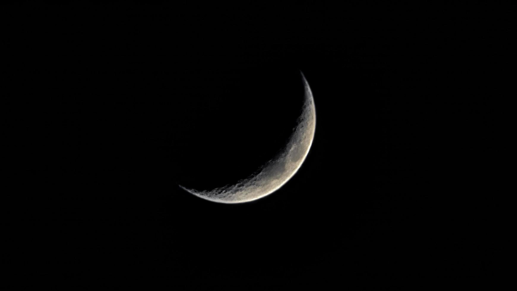lune cornue souriante dans le ciel noir. photo