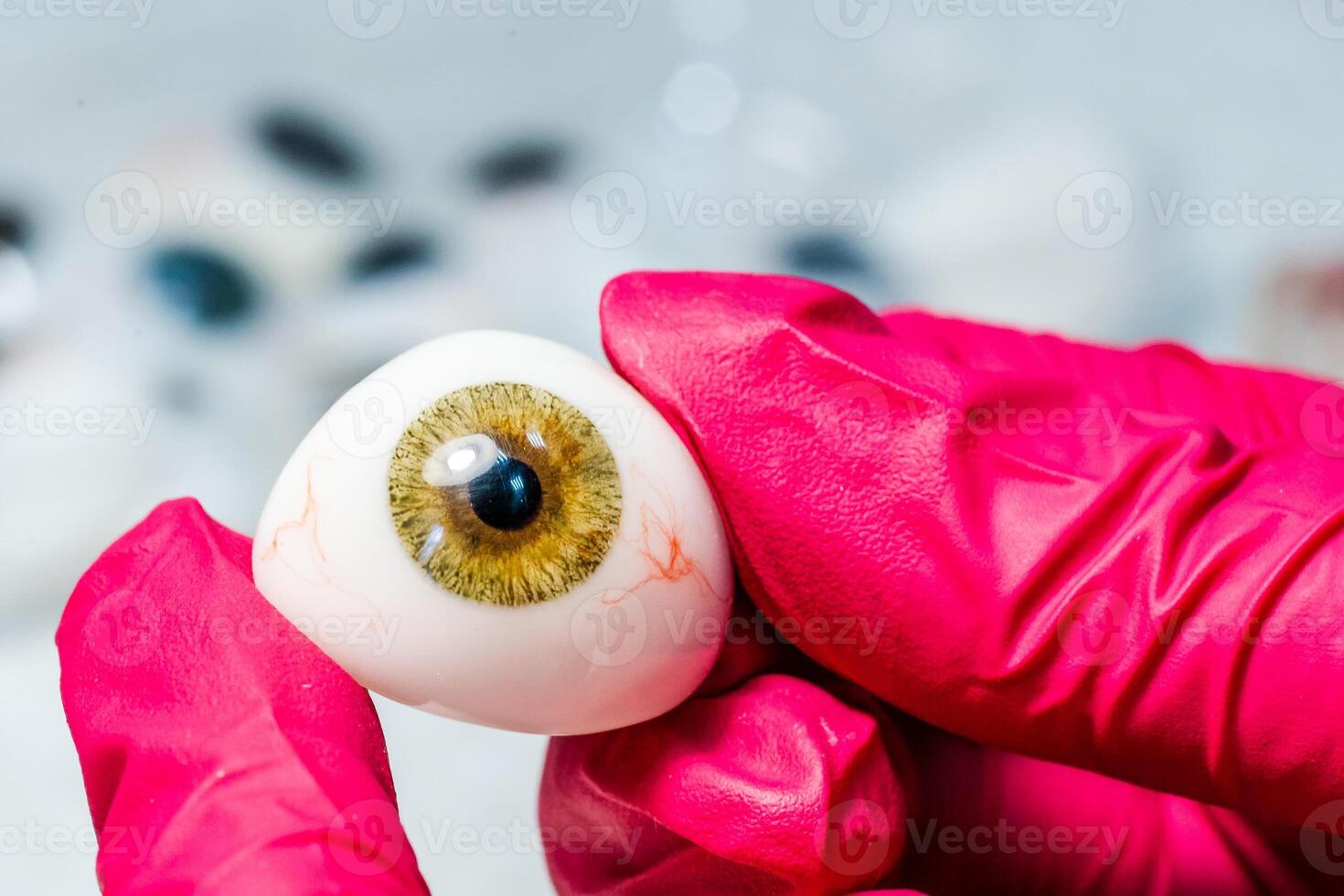ophtalmologiste ou chirurgien détient un œil, globe oculaire prothèse dans mains. concept photo pour oculaire prothèse. chirurgical opérations sur yeux. fermer.