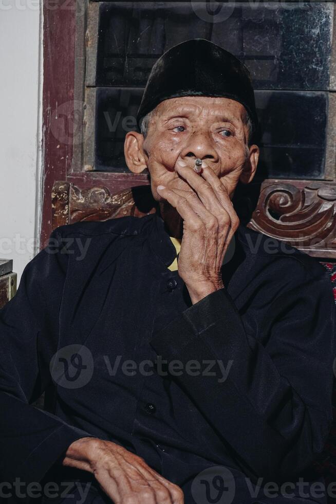 portrait de un personnes âgées asiatique homme fumeur une cigarette. photo