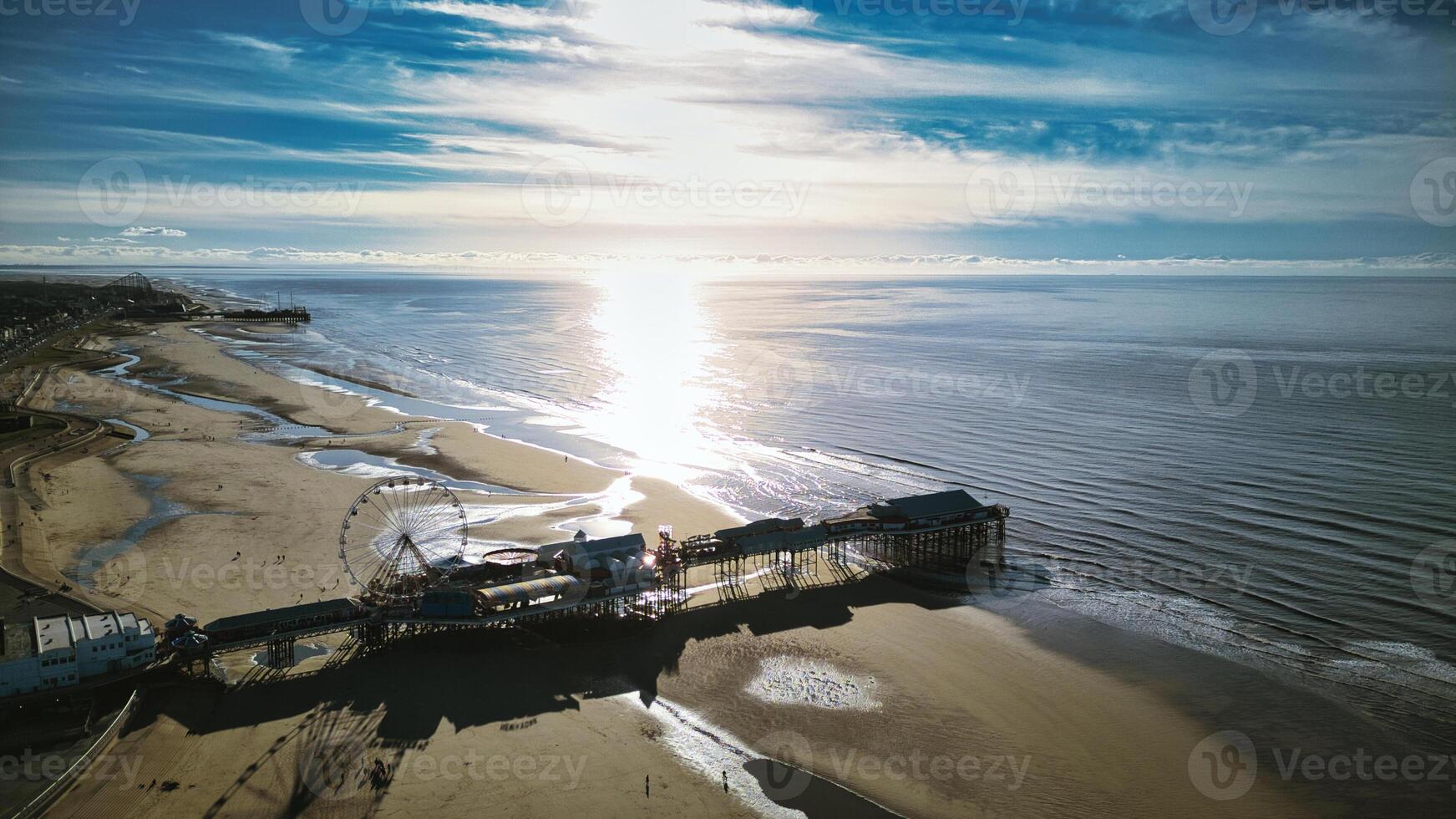 aérien vue de une ensoleillé plage avec une jetée extension dans calme des eaux, moulage ombres sur le le sable dans backpool, Angleterre. photo