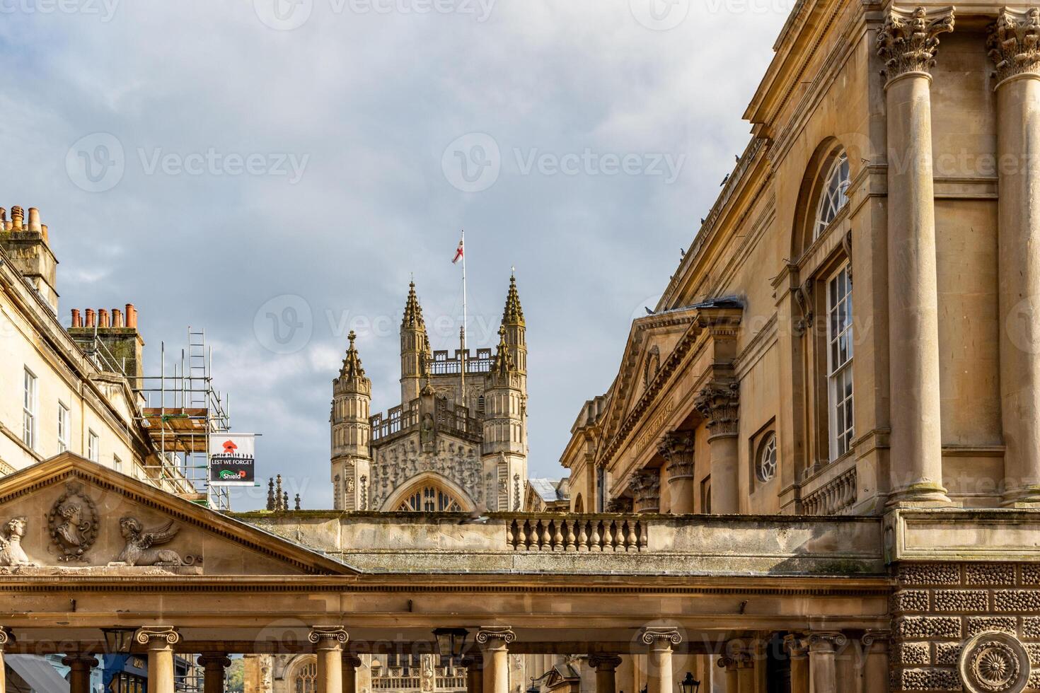 élégant historique architecture avec fleuri façades en dessous de une nuageux ciel dans bain, Angleterre. photo