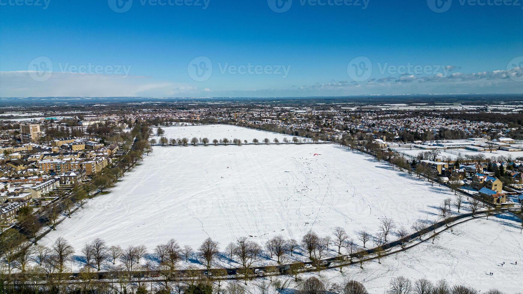 aérien vue de une neigeux paysage avec une route partage Urbain et rural zones en dessous de une clair bleu ciel dans harroquer, Nord Yorkshire. photo