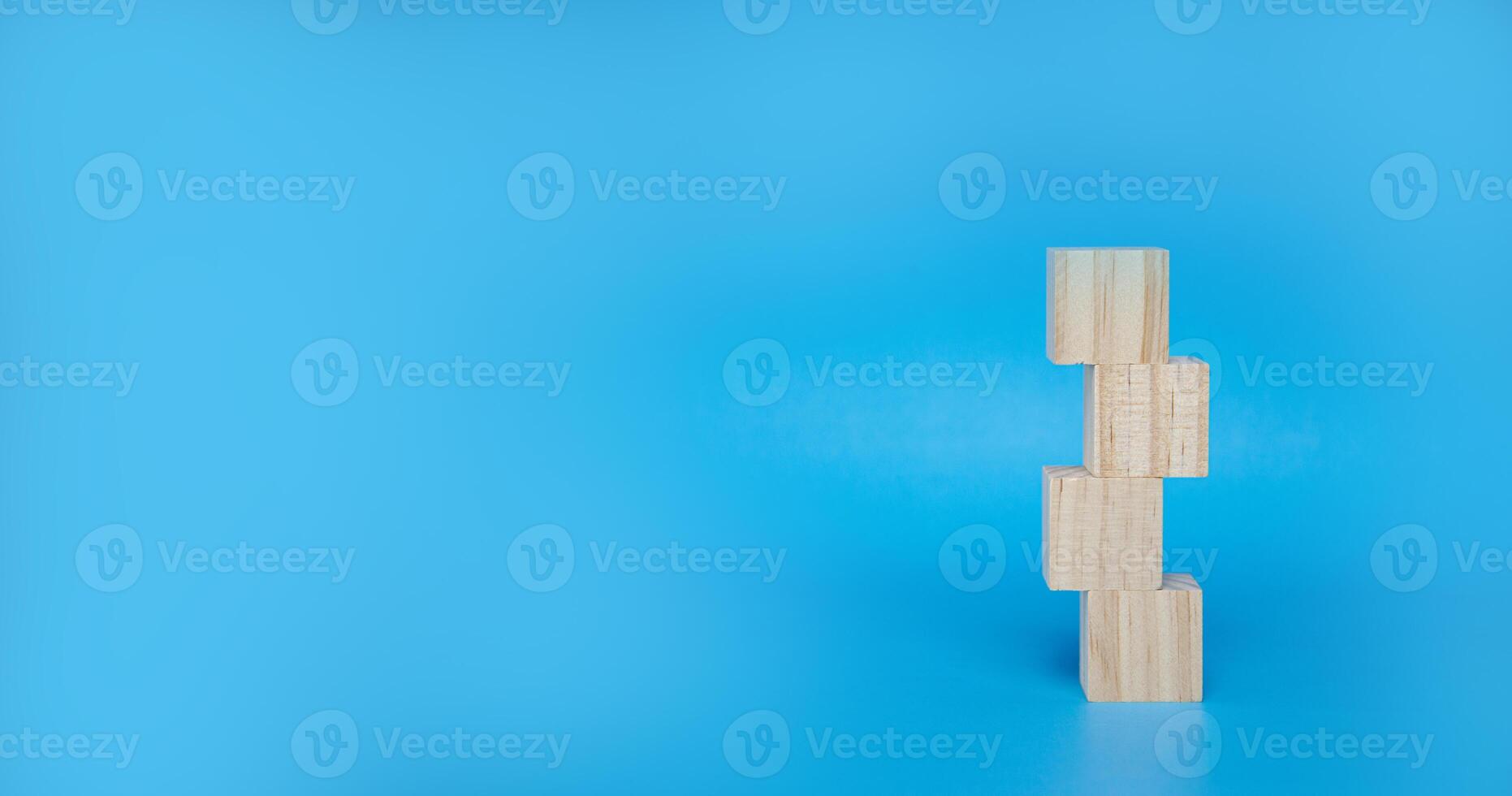 cubique en bois bloquer empilés sur une bleu Contexte photo