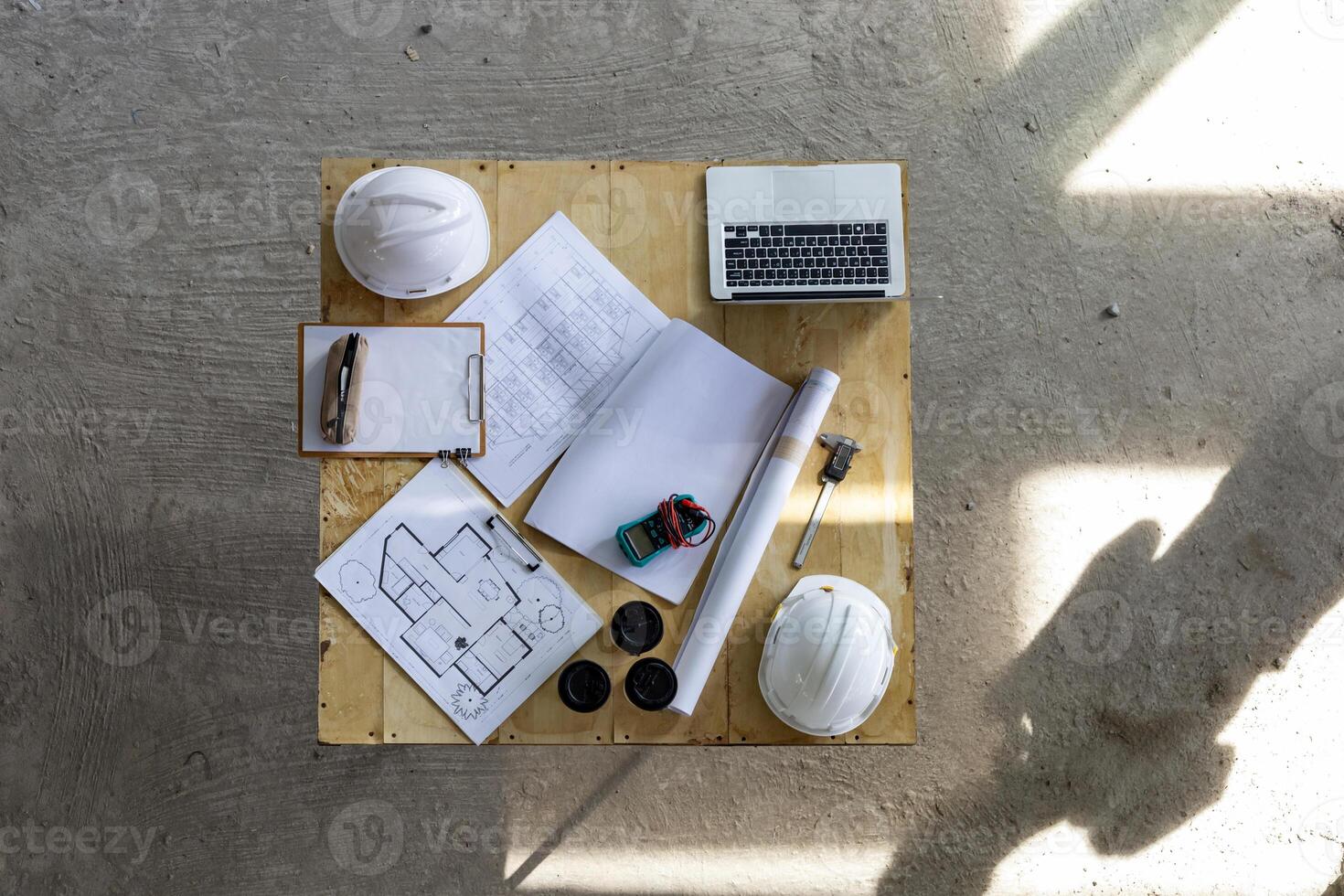 ingénieur et ouvrier table réunion à le construction bâtiment site avec sol plan pour réel biens développement projet industrie et logement chronologie usage photo