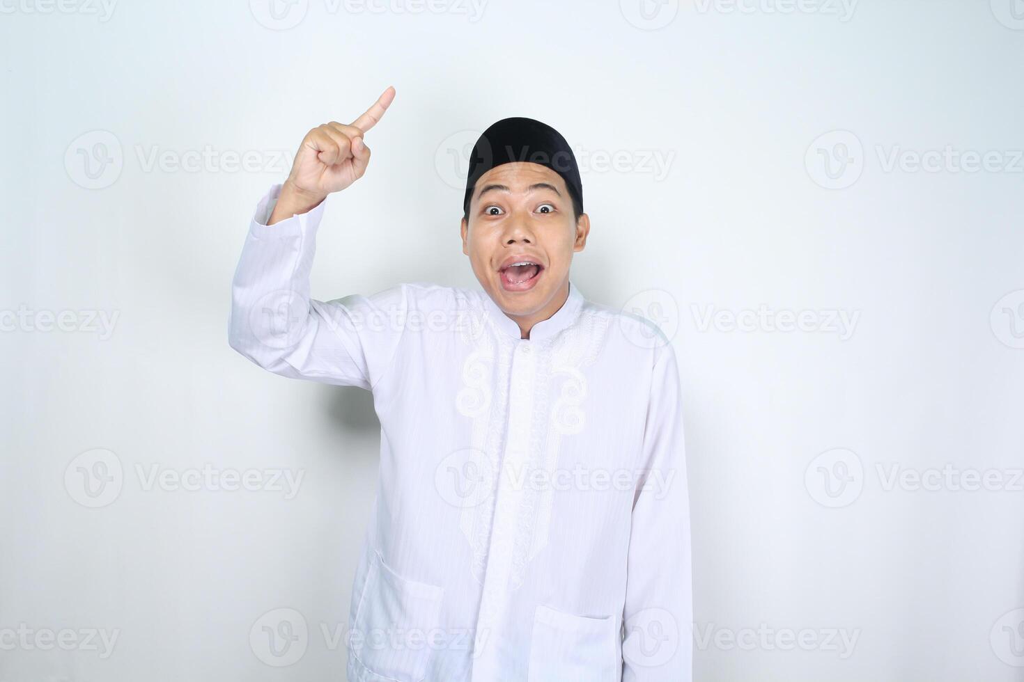surpris asiatique musulman homme montrer du doigt à au dessus isolé sur blanc Contexte photo