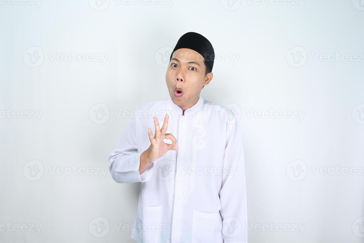 marrant musulman homme asiatique donner d'accord panneaux avec sous le choc expression isolé sur blanc Contexte photo