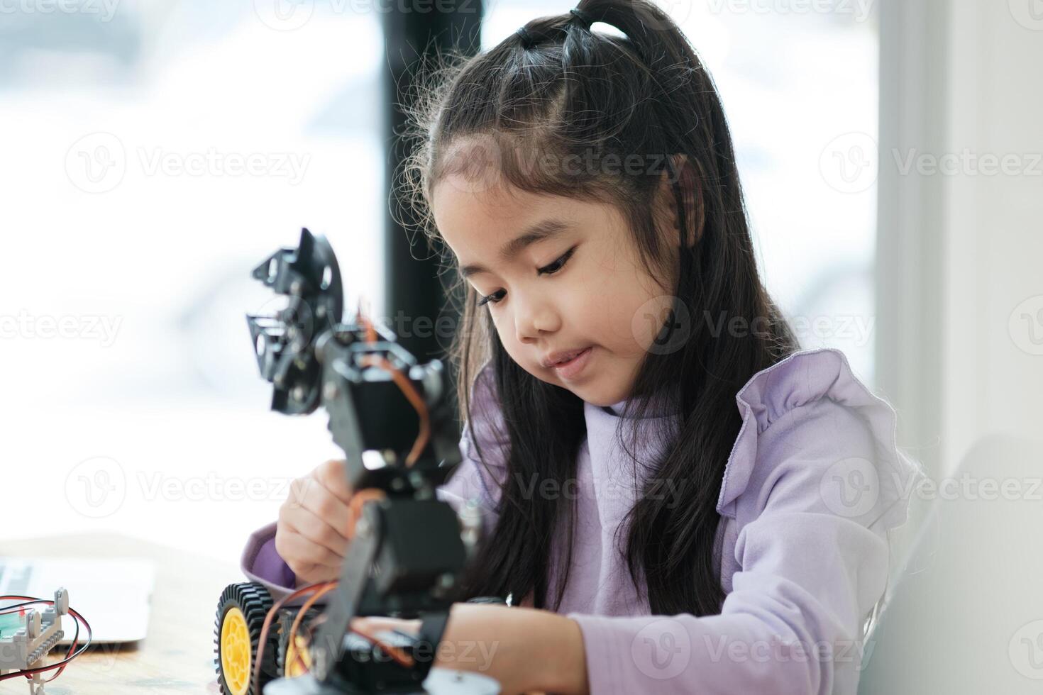 tige éducation concept. asiatique Jeune fille apprentissage robot conception. photo