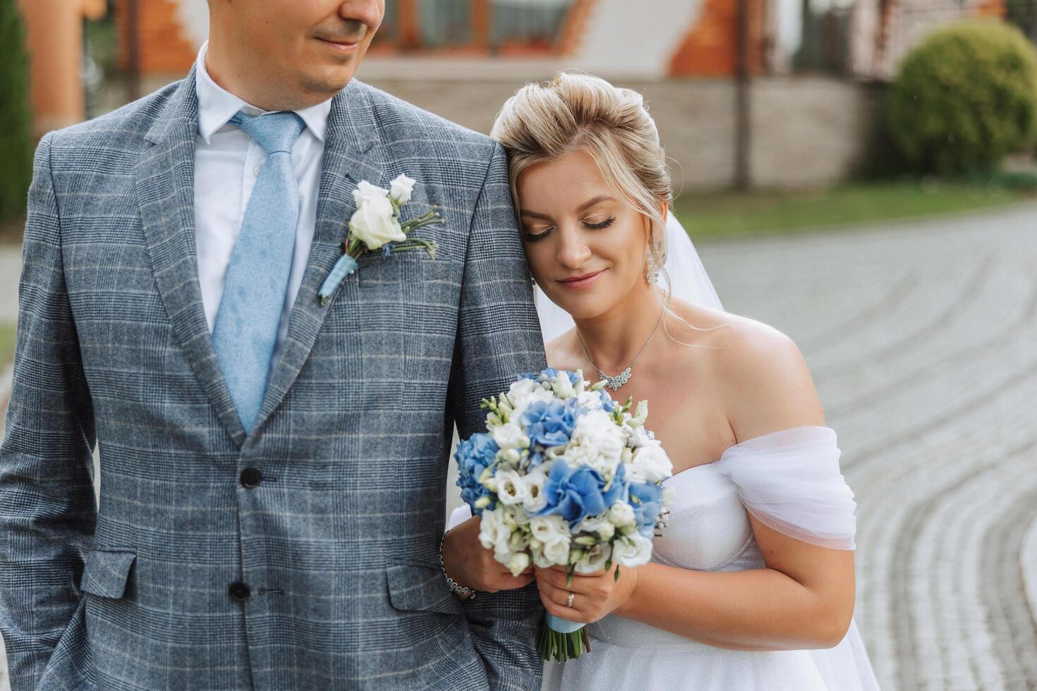 le la mariée et jeune marié embrasser. le la mariée doucement câlins le jeune marié par le épaules. magnifique mariage couple. le concept de romance dans une jeunes mariés relation. voyage de noces. photo