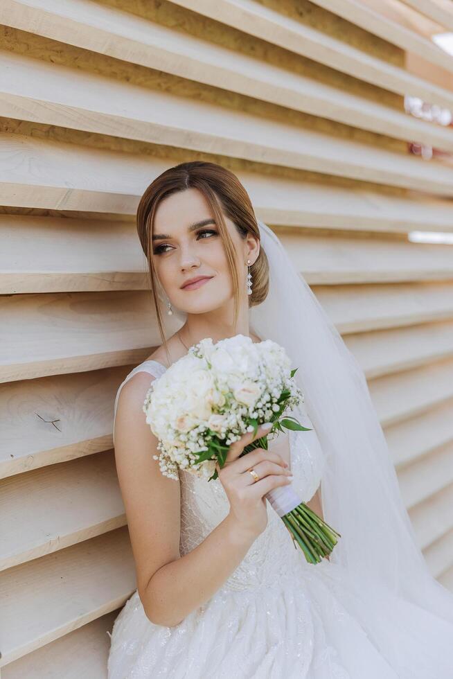 magnifique la mariée avec mariage fleurs bouquet, attrayant femme dans mariage robe. content nouveau marié femme. la mariée avec mariage maquillage et coiffure. souriant la mariée. mariage journée. magnifique la mariée. mariage. photo