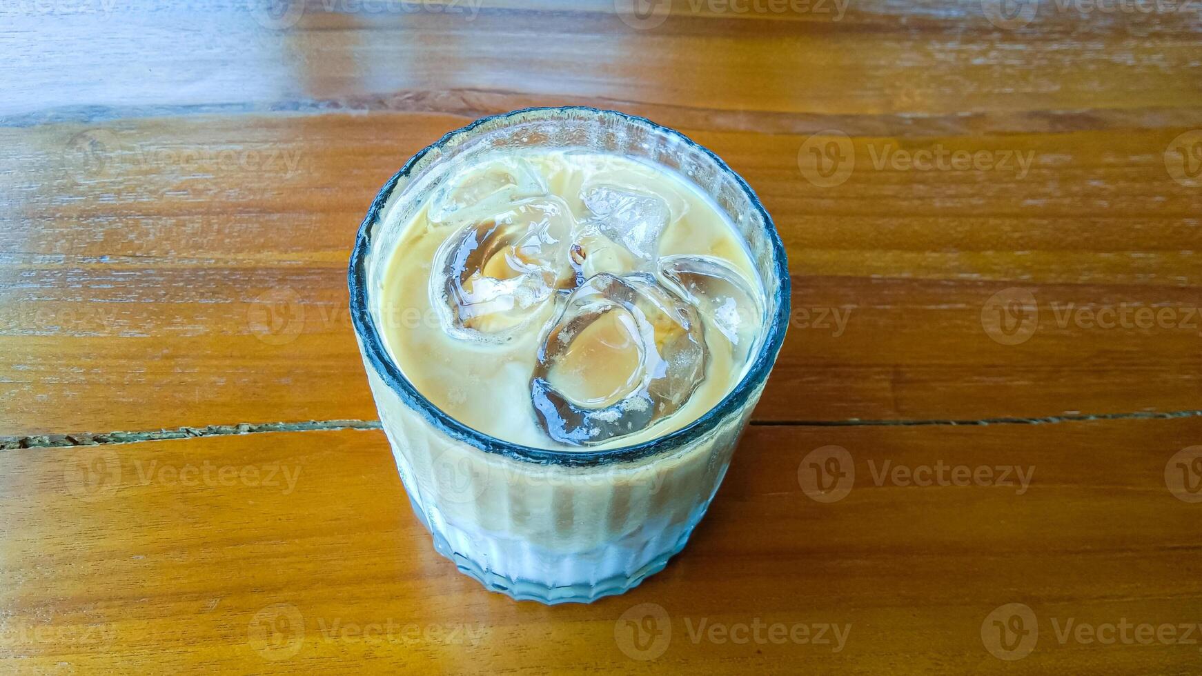 une verre de du froid cappuccino sur une en bois table photo