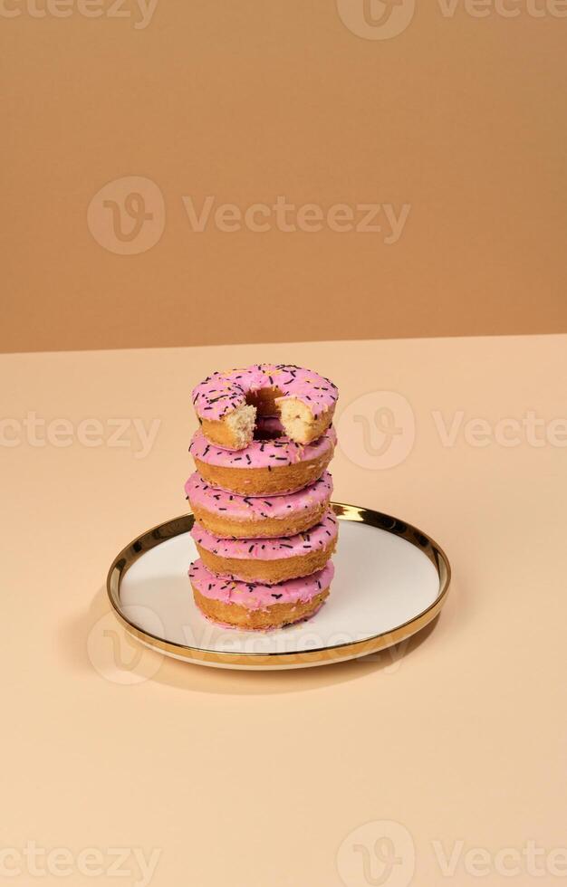 Donut couvert avec rose glaçage et saupoudré avec coloré arrose sur une rond plaque, marron Contexte photo