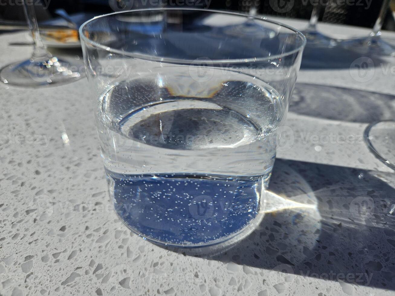 concentré vue de une rempli verre de l'eau dans Soleil réflexion photo