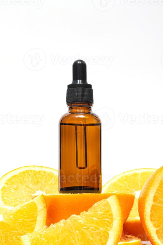 vitamine c sérum dans un ambre bouteille avec une pipette sur une Contexte de Orange agrumes des fruits. agrumes essentiel huile, aromathérapie produits de beauté. biologique spa produits de beauté avec à base de plantes Ingrédients photo