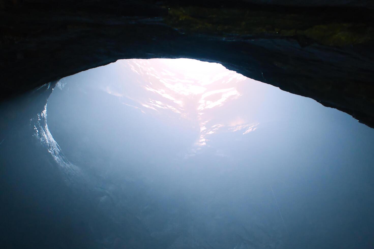 grotte rocheuse avec trou à travers lequel la lumière brille. mondes souterrains en suède. mystique photo