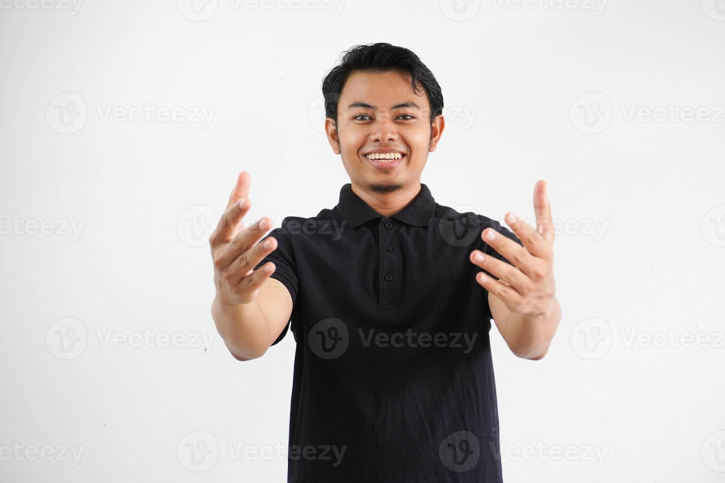 Jeune asiatique homme souriant lorsque montrant saluer geste portant noir polo t chemise isolé sur blanc Contexte photo