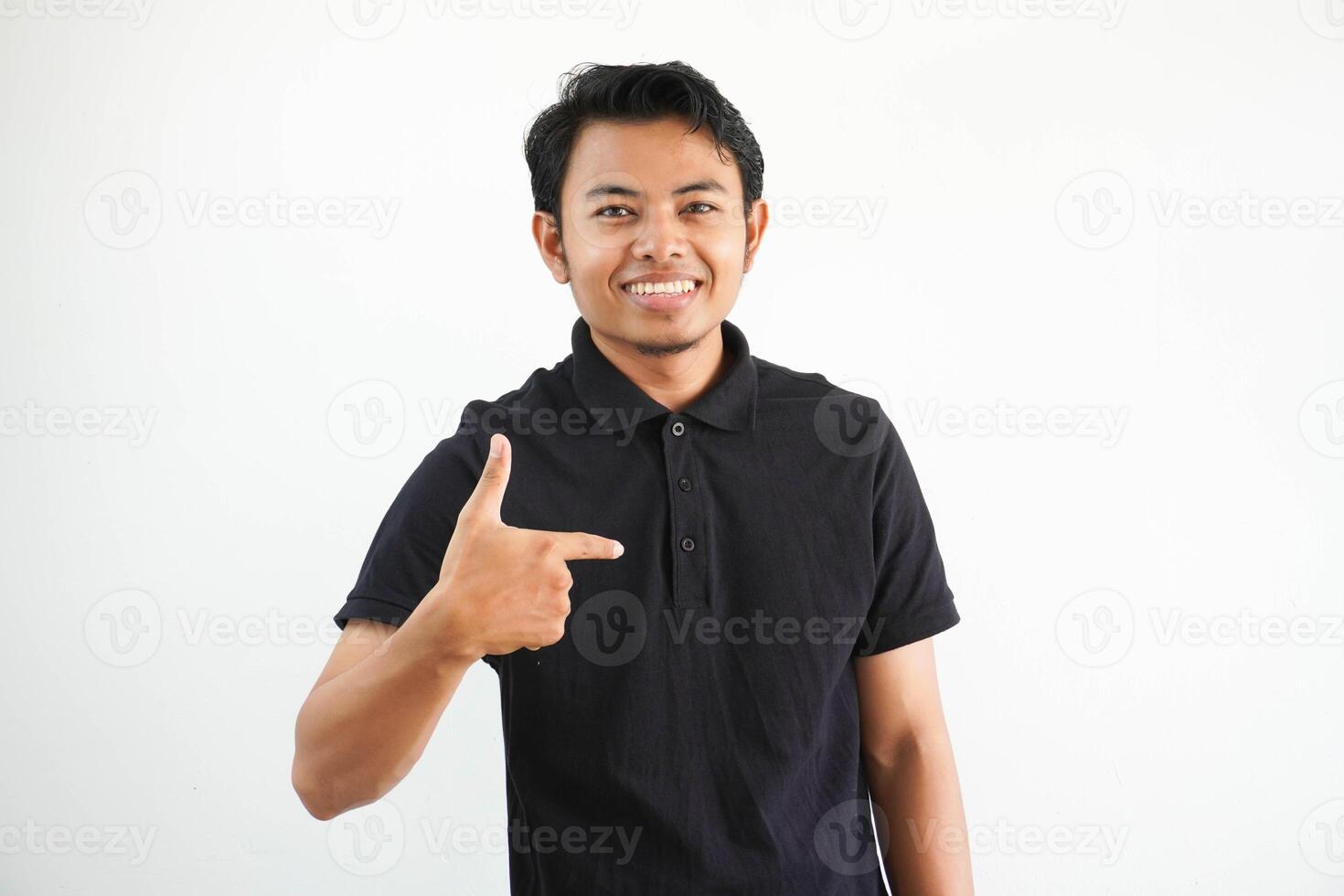 souriant Jeune asiatique homme montrer du doigt à lui-même avec excité expression portant noir polo t chemise isolé sur blanc Contexte. photo