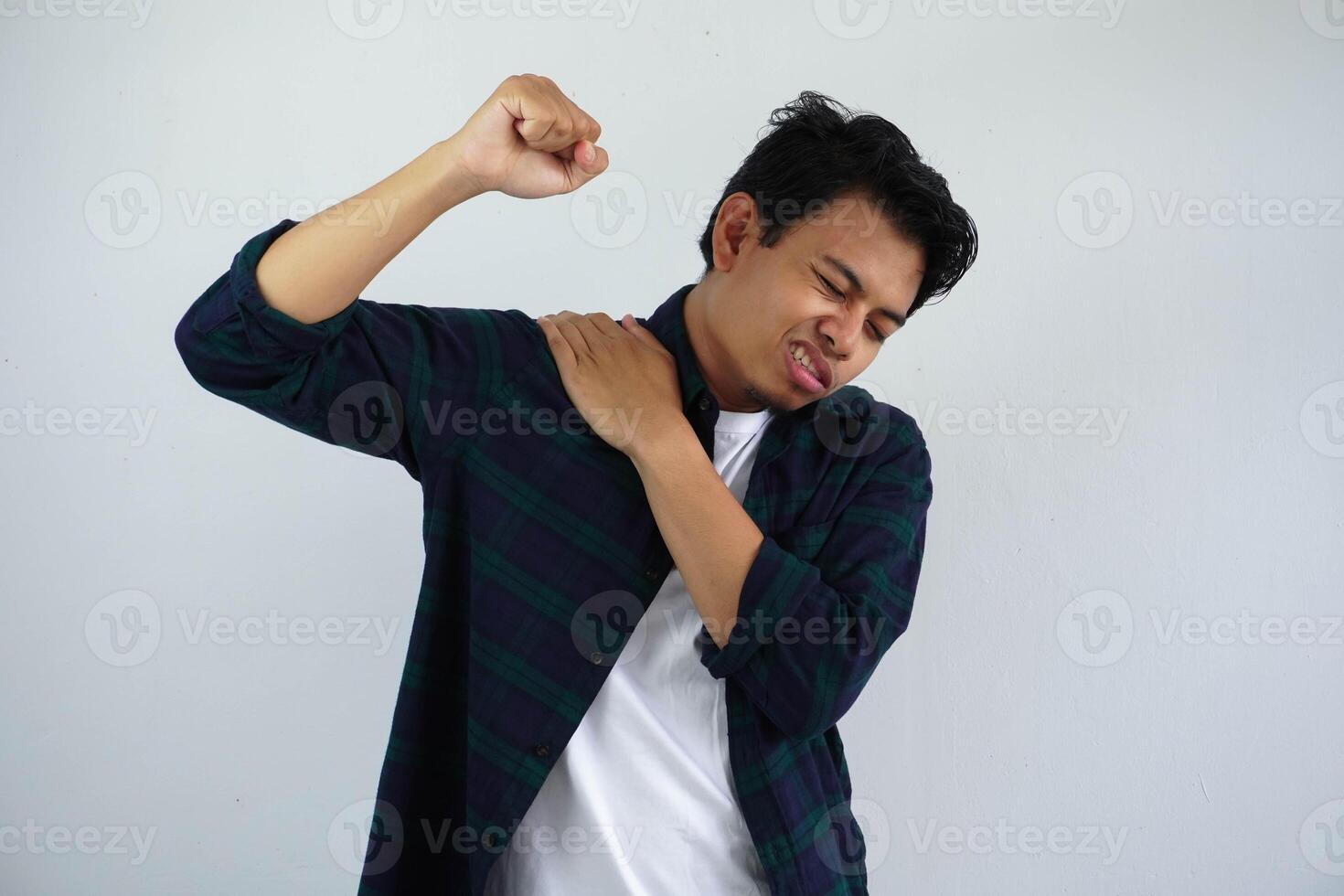 Jeune asiatique homme émouvant le sien droite épaule avec douleur expression isolé sur blanc Contexte. photo