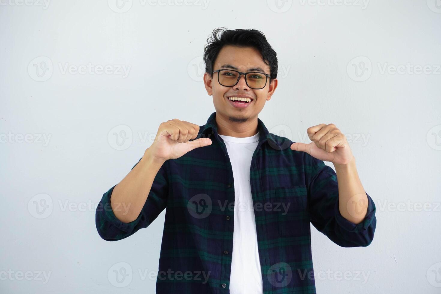 Jeune asiatique homme montrant enthousiaste expression tandis que montrer du doigt à le sien soi isolé sur blanc Contexte. photo