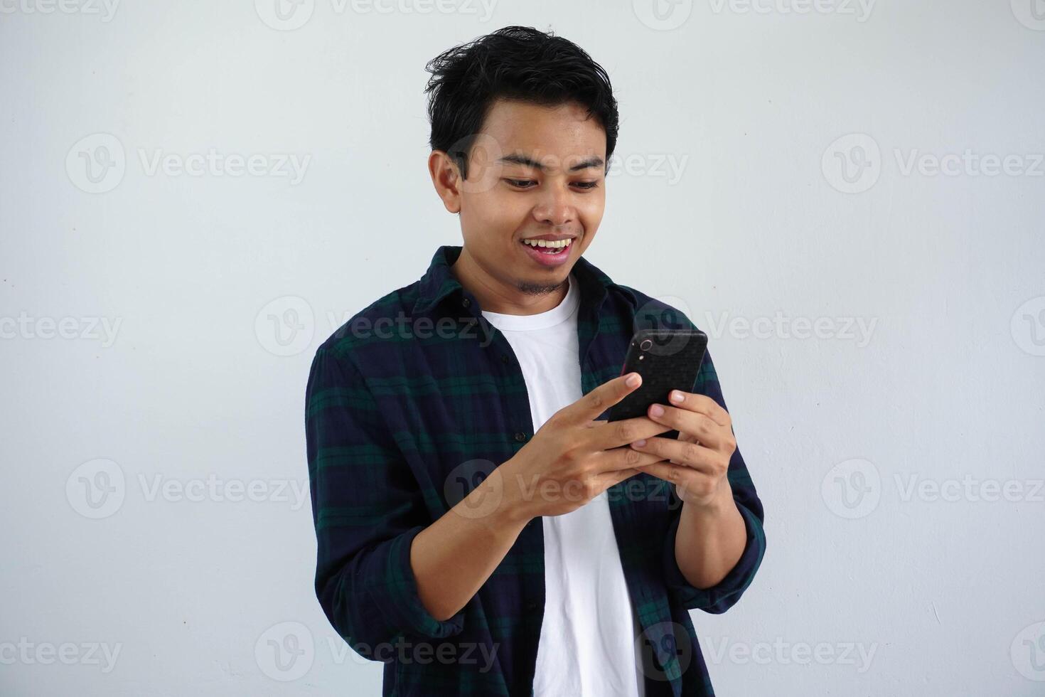 souriant ou content visage Jeune asiatique homme tandis que en utilisant mobile téléphone isolé blanc Contexte photo