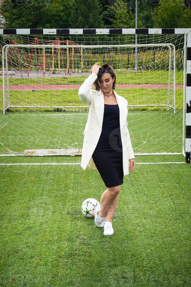 portrait de une magnifique femme Football joueur dans une strict Bureau costume. photo