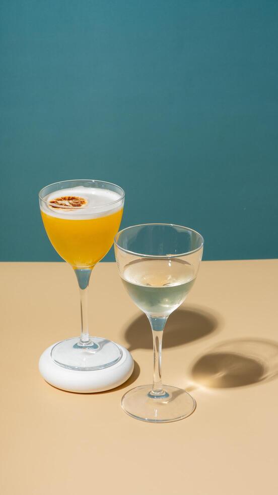 deux des lunettes avec un alcoolique cocktail décoration sec Orange sur une coloré Contexte photo