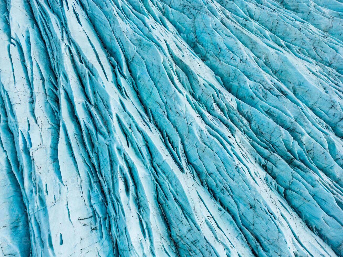 aérien vue de bleu la glace glaciers avec crevasses, vatnajokull la glace Masse et glacier lagune avec gelé du froid l'eau dans Islande. diamant bleu glacé rochers alentours scandinave lac, climat changement. photo