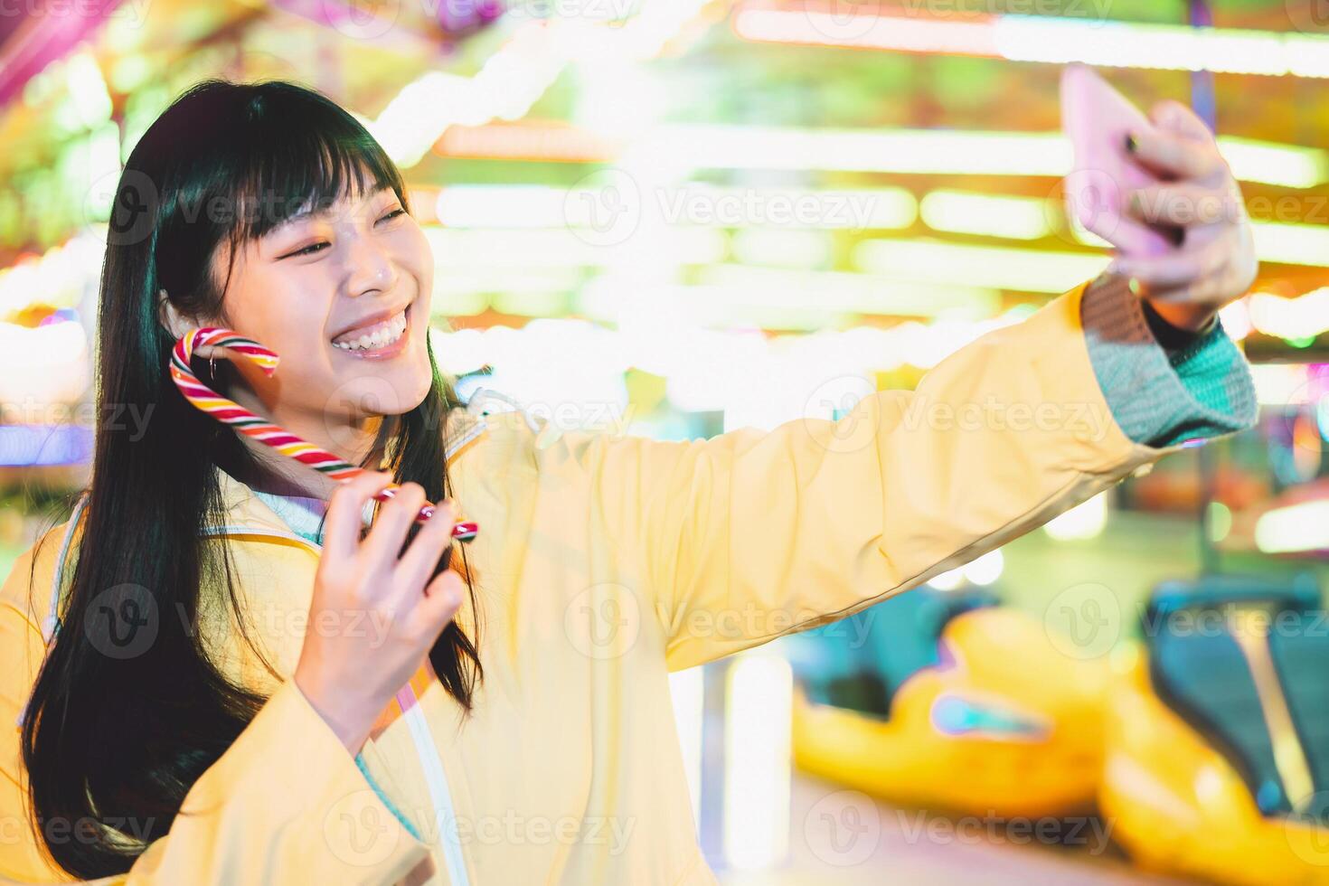 asiatique fille prise selfie avec mobile téléphone dans amusement parc - content femme ayant amusement avec Nouveau les tendances téléphone intelligent applications - jeunesse millénaire gens génération et social médias dépendance concept photo