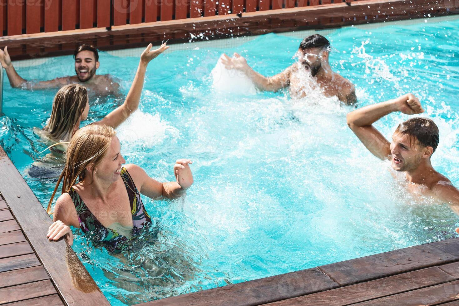 Jeune gens ayant amusement dans exclusif bassin fête - content copains profiter été vacances dans nager bassin - jeunesse vacances mode de vie concept photo