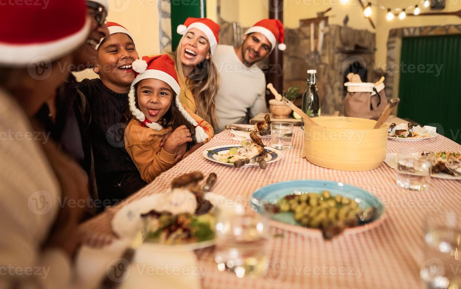 content Latin famille ayant amusement célébrer Noël vacances tandis que à manger ensemble à Accueil photo