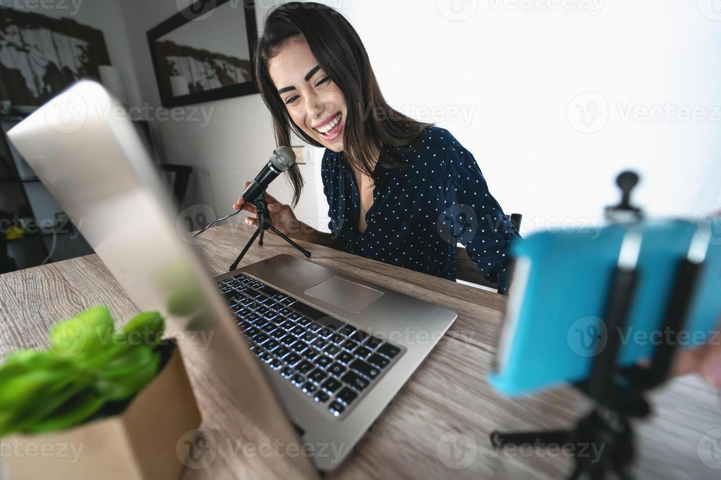 content femme tournage vidéo Podcast avec intelligent téléphone caméra tandis que en utilisant ordinateur - Jeune fille ayant amusement dans vivre diffusion sur social réseaux - jeunesse gens mode de vie et La technologie concept photo