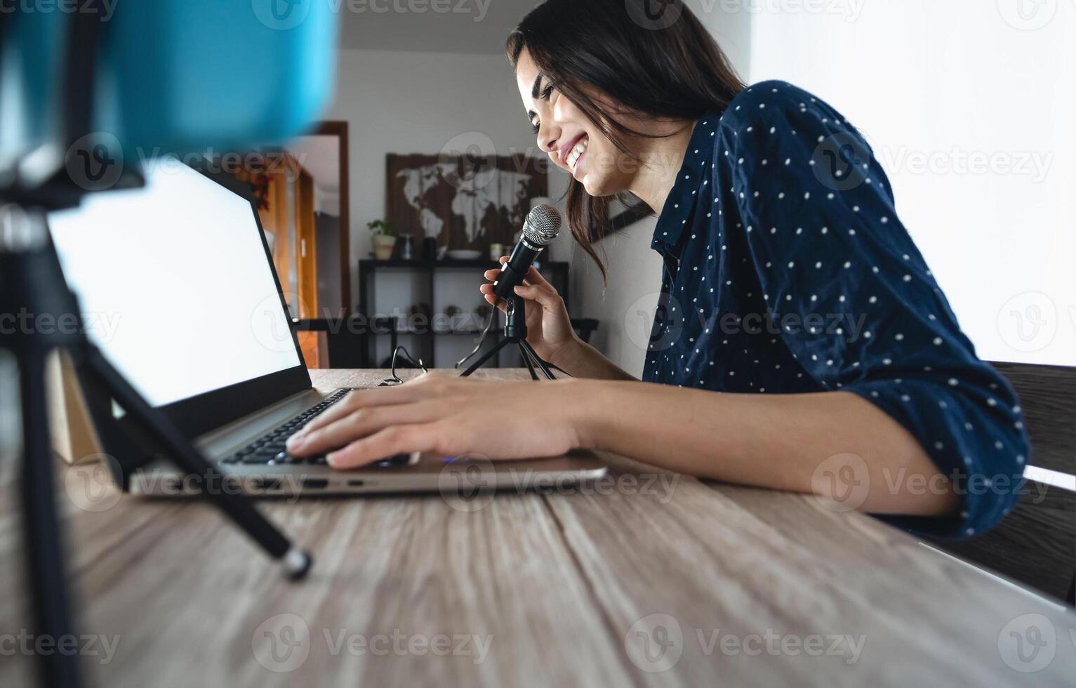 content femme tournage vidéo Podcast avec intelligent téléphone caméra tandis que en utilisant ordinateur - Jeune fille ayant amusement dans vivre diffusion sur social réseaux - jeunesse gens mode de vie et La technologie concept photo