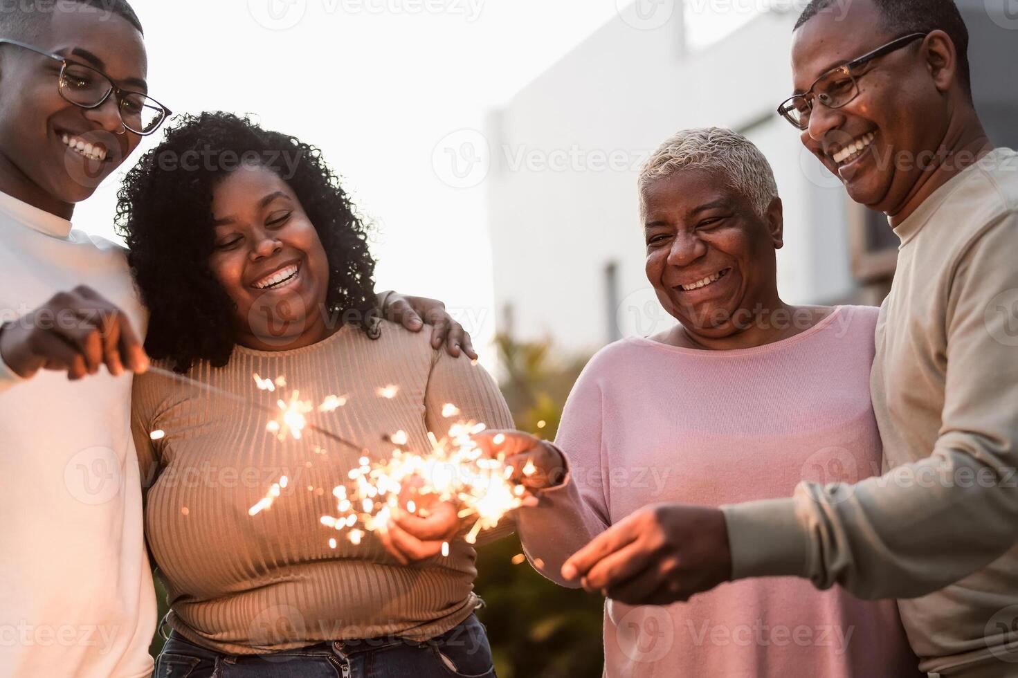 content africain famille célébrer avec cierges magiques feux d'artifice à maison fête - Parents unité et vacances concept photo