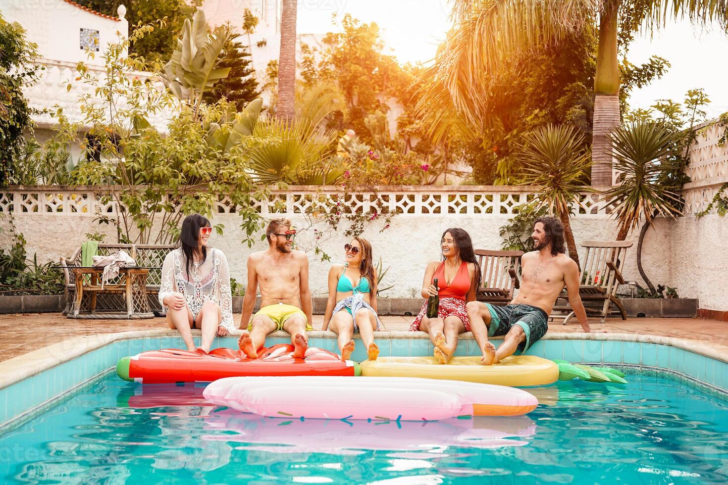 groupe de content copains relaxant dans nager bassin - Jeune gens ayant amusement dans exclusif été tropical vacances - amitié, vacances et jeunesse mode de vie concept photo