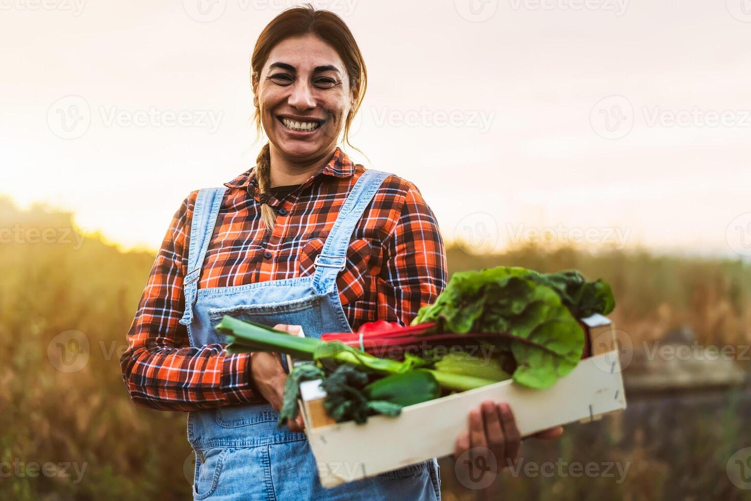 une femme en portant une boîte de Frais des légumes photo