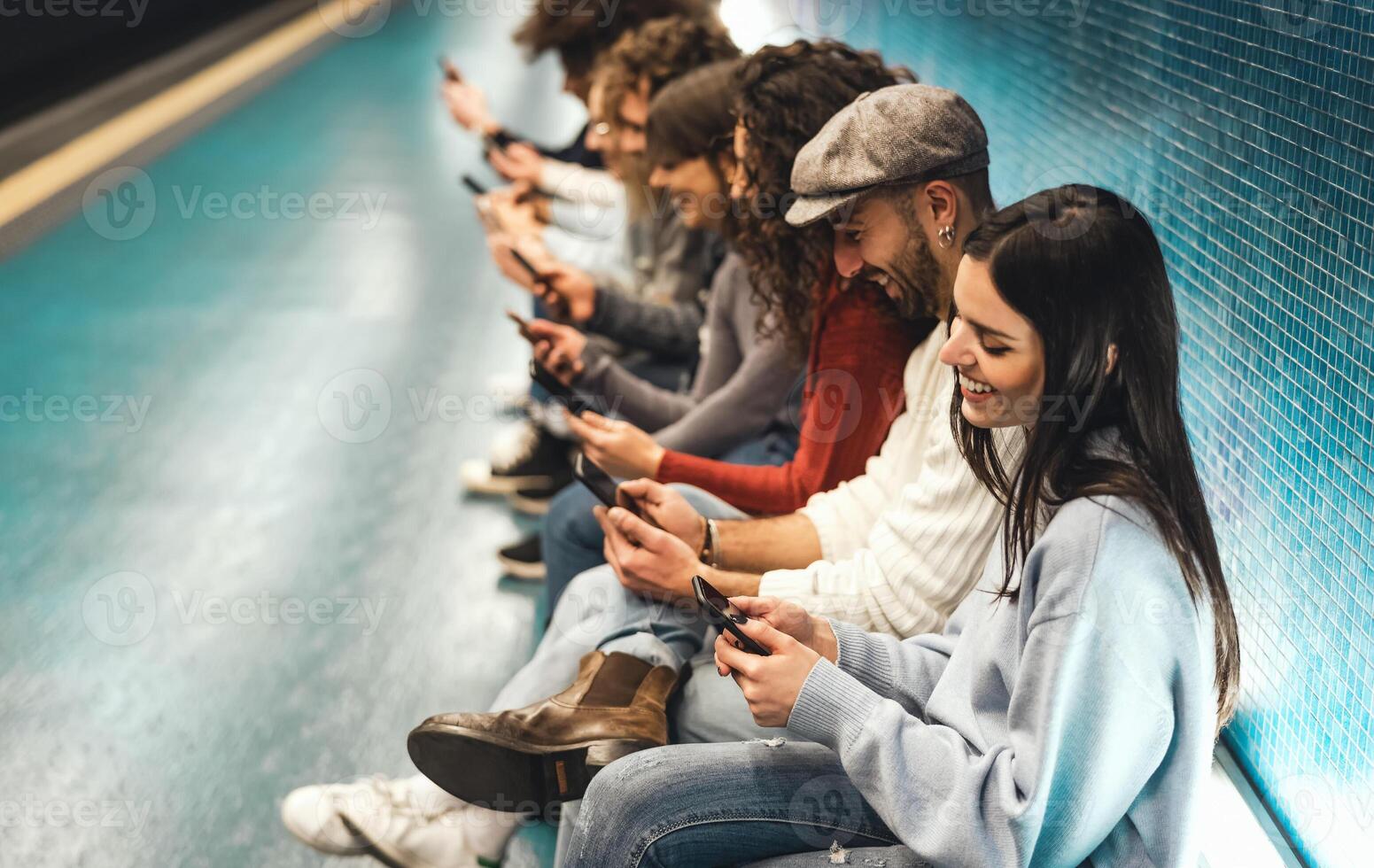 Jeune gens en utilisant mobile téléphone intelligent tandis que séance dans métro attendre train - jeunesse millénaire intoxiqué à Nouveau La technologie concept photo