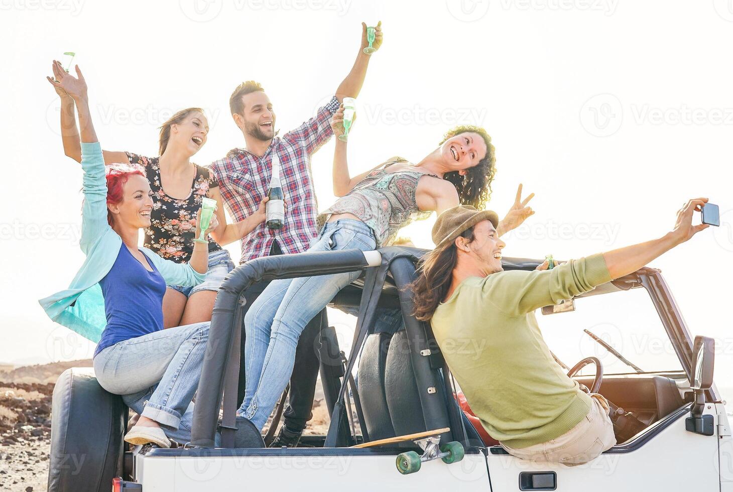 groupe de content copains prise selfie avec mobile intelligent téléphone sur convertible voiture - Jeune gens ayant amusement fabrication fête pendant leur route voyage - amitié, vacances, jeunesse vacances mode de vie concept photo